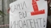 Russia -- A journalist holds a placard which reads "Foreign agents yourself" near the headquarters of Federal Security Service in Moscow